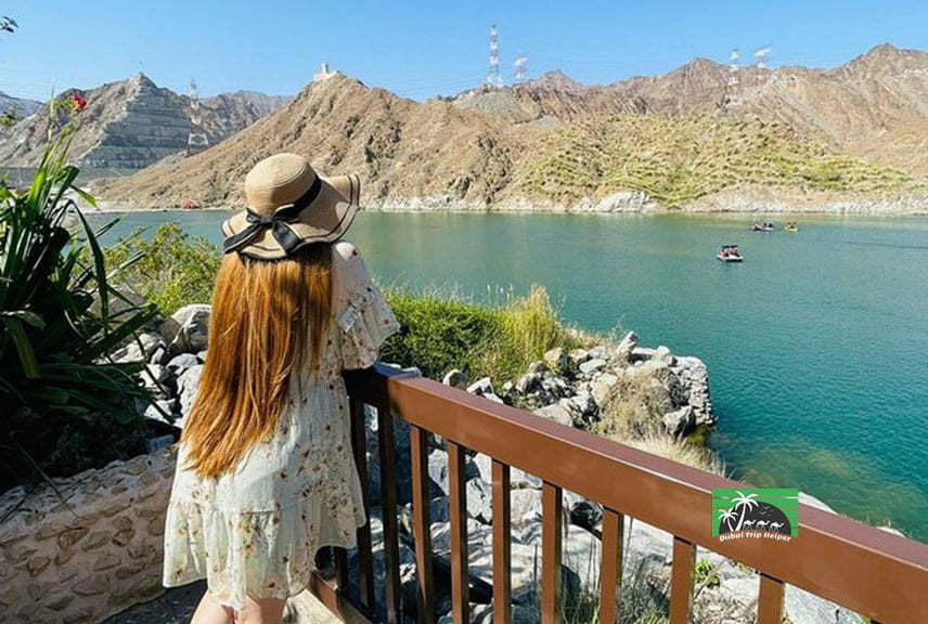 A lady standing at the bank of lake watching at the mountains with beautiful view