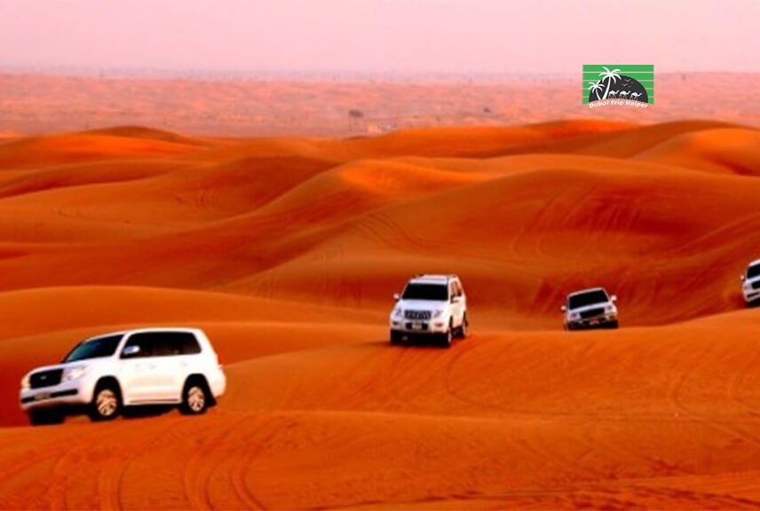 a group of land cruise in desert safari dubai with red sand dunes in Dubai